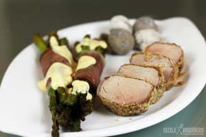 Schweinefilet mit Kruste, grüner Spargel und Runzelkartoffeln angerichtet