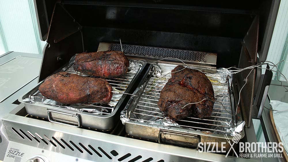 Drei Schweinenacken liegen auf dem Gasgrill