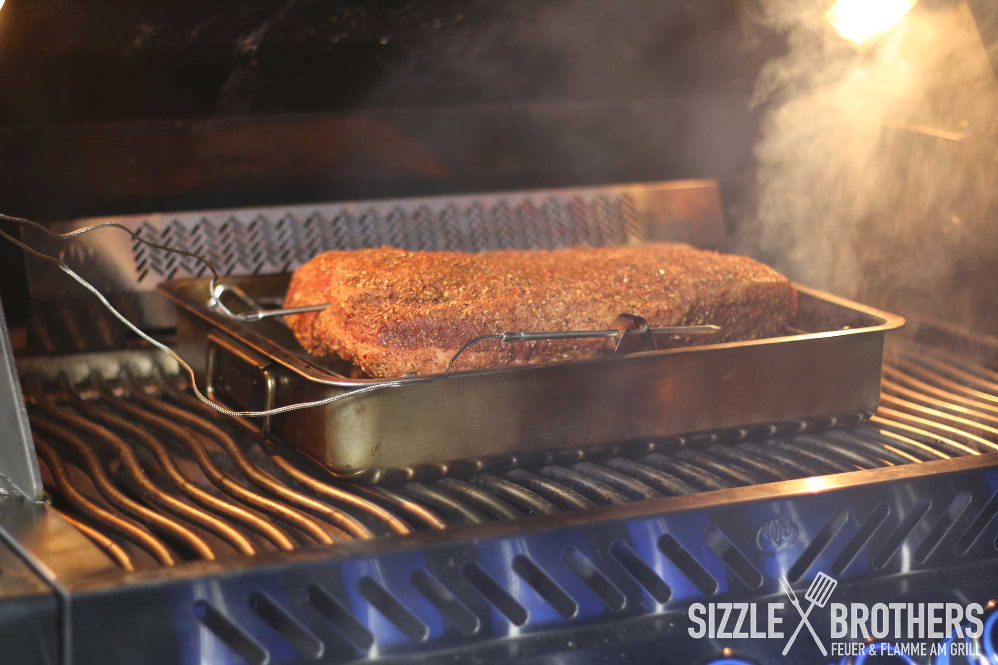 Das Brisket liegt im Gasgrill auf einer Schale