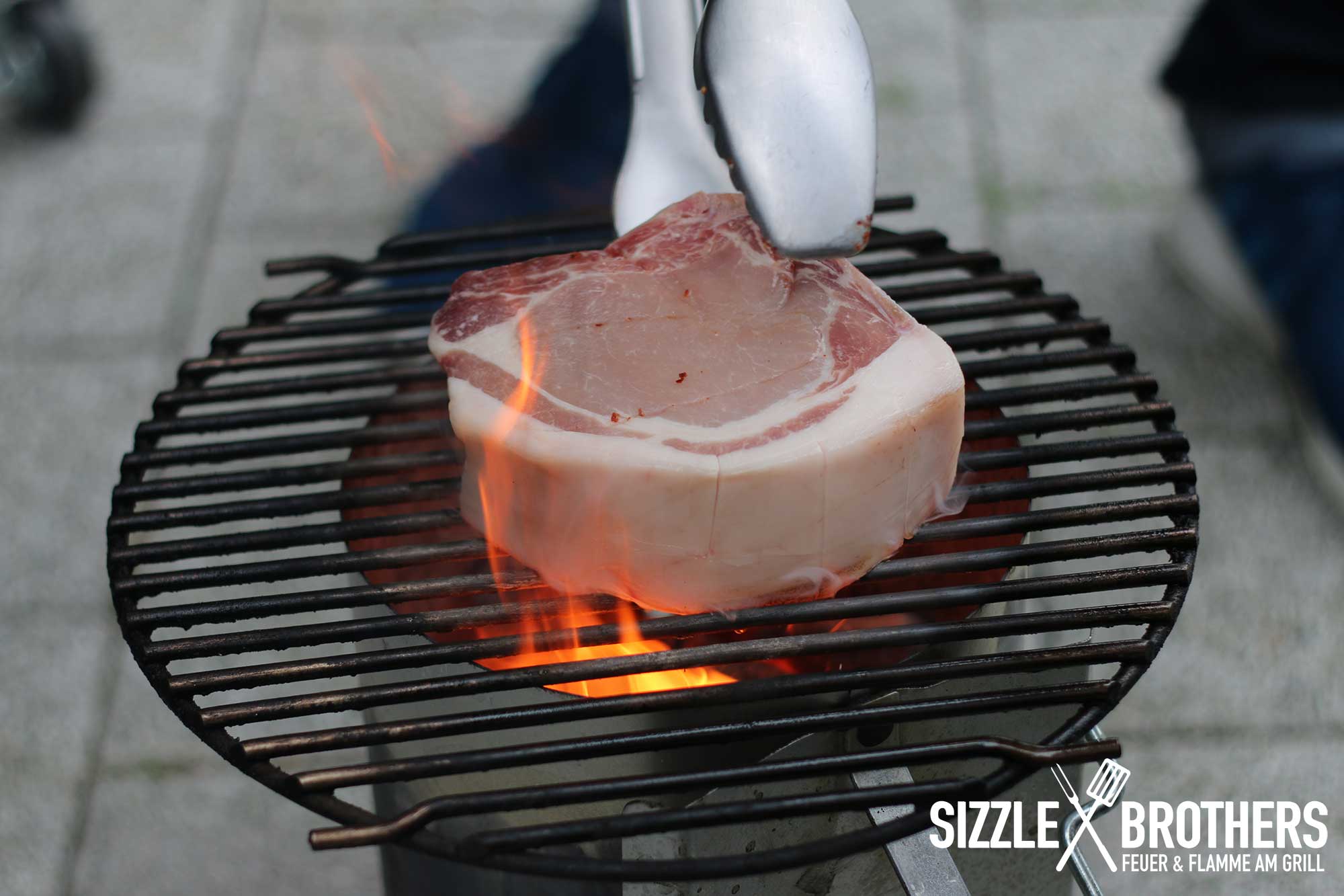 AZK Steak - Das Schweinesteak wird auf dem Anzündkamin angebraten