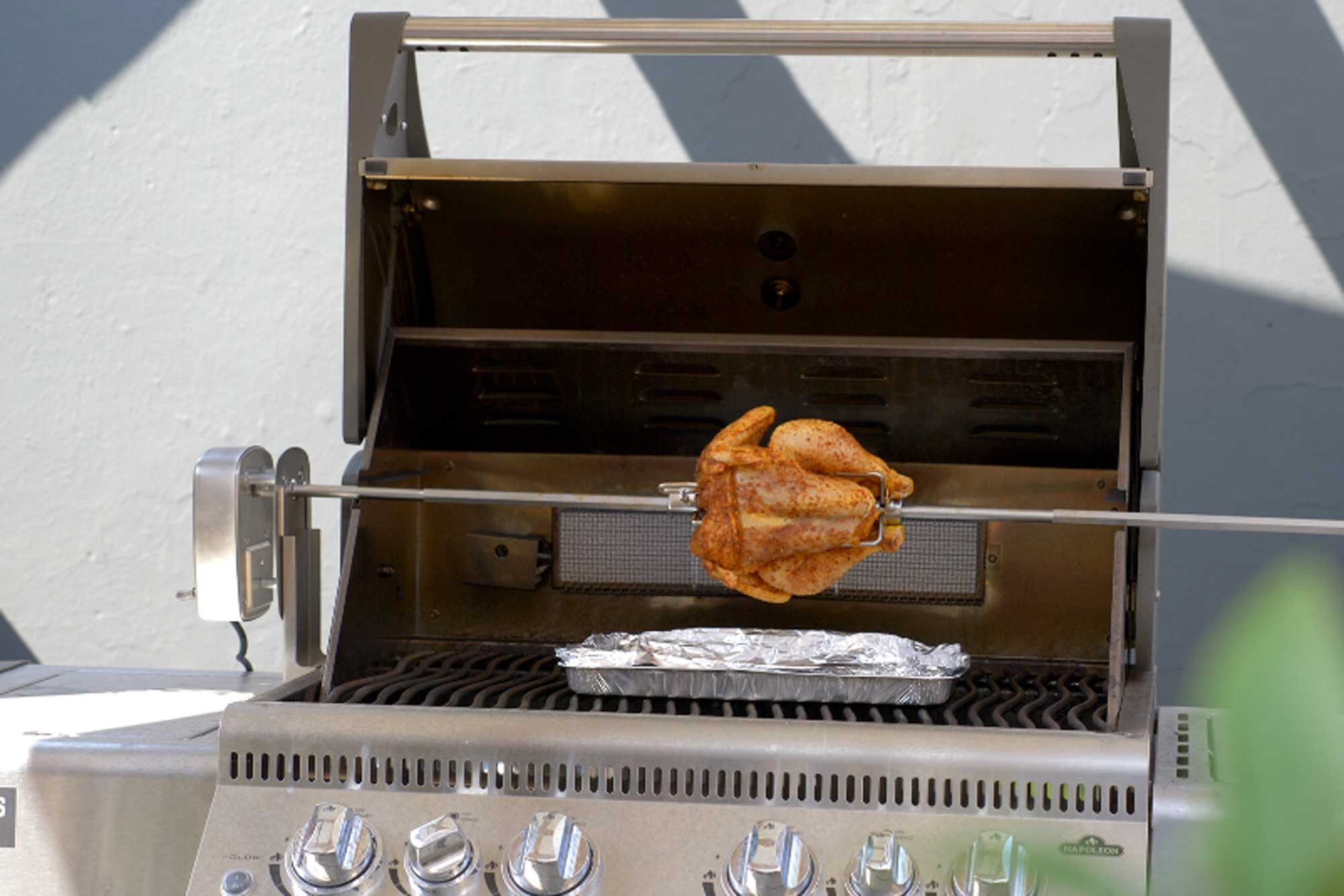 Hähnchen am Drehspieß über dem Grill
