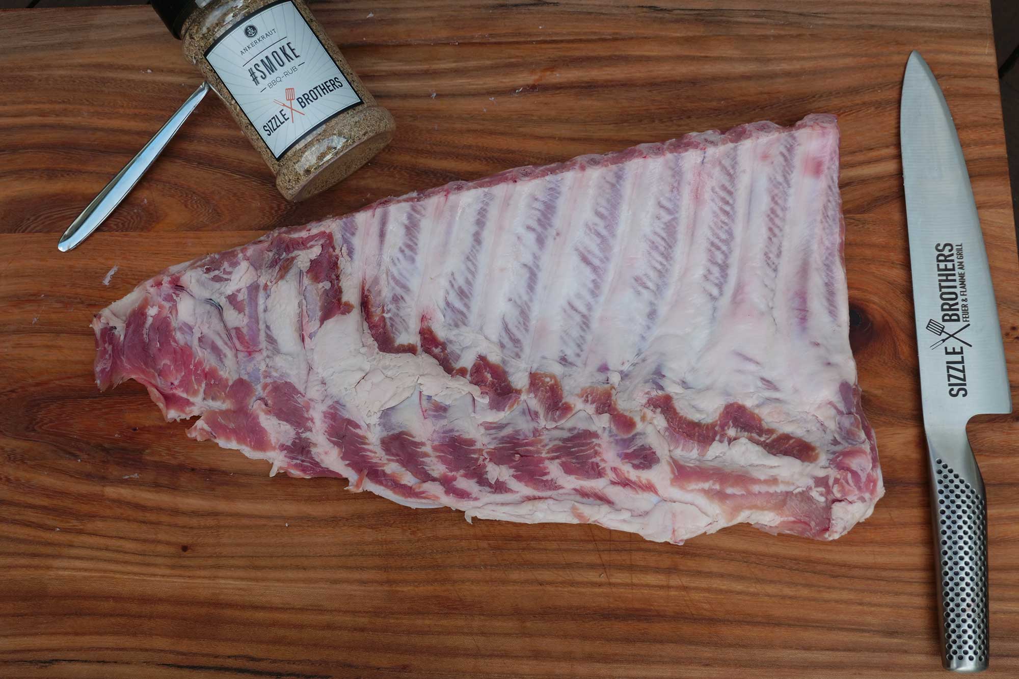 Auf der Knochenseite der Spareribs wird die Silberhaut entfernt