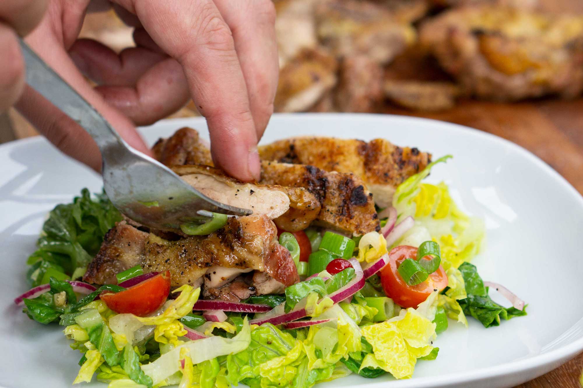 Salat mit Hähnchenstreifen wird angerichtet