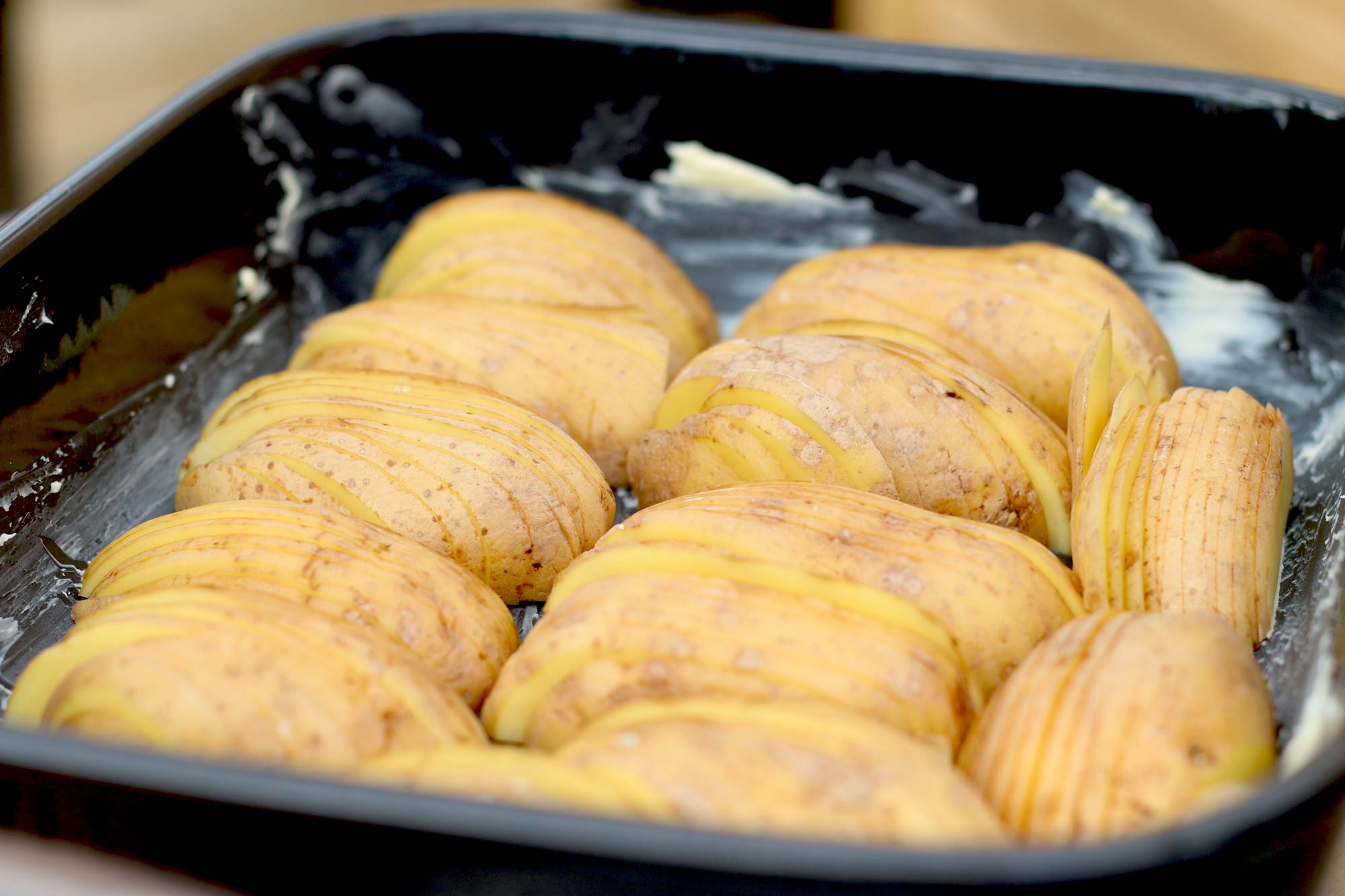Die Kartoffelscheiben in der Auflaufform stapeln