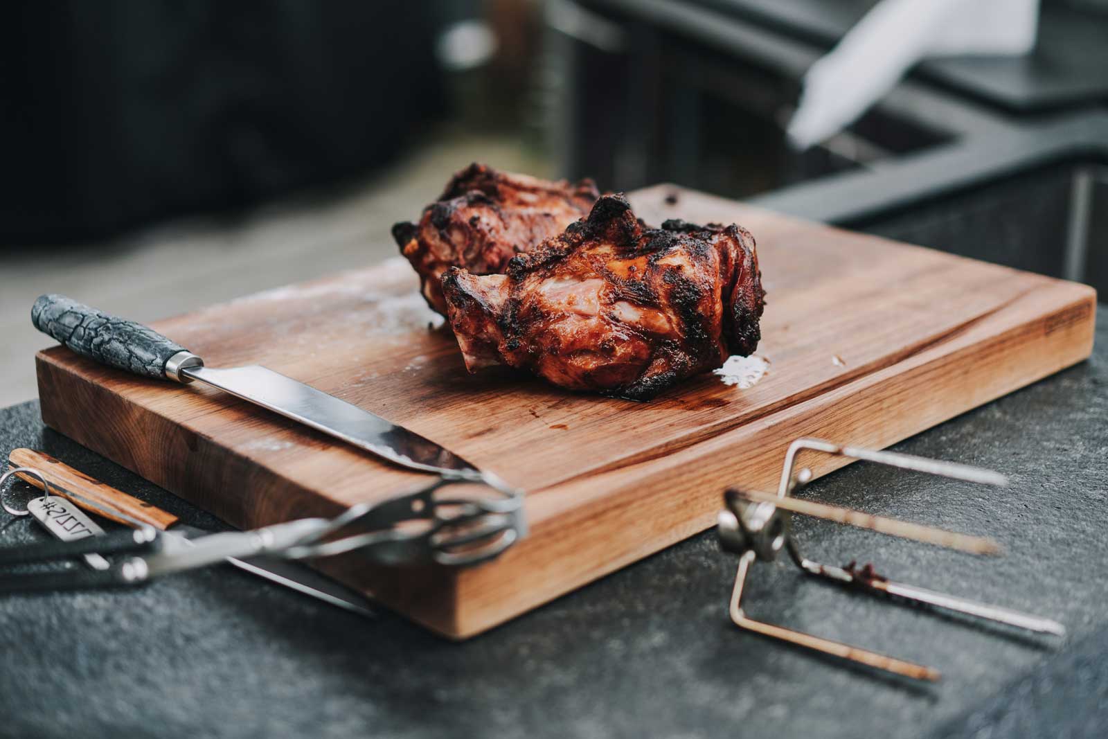 Die Haxen wandern frisch vom Grill auf das Brett