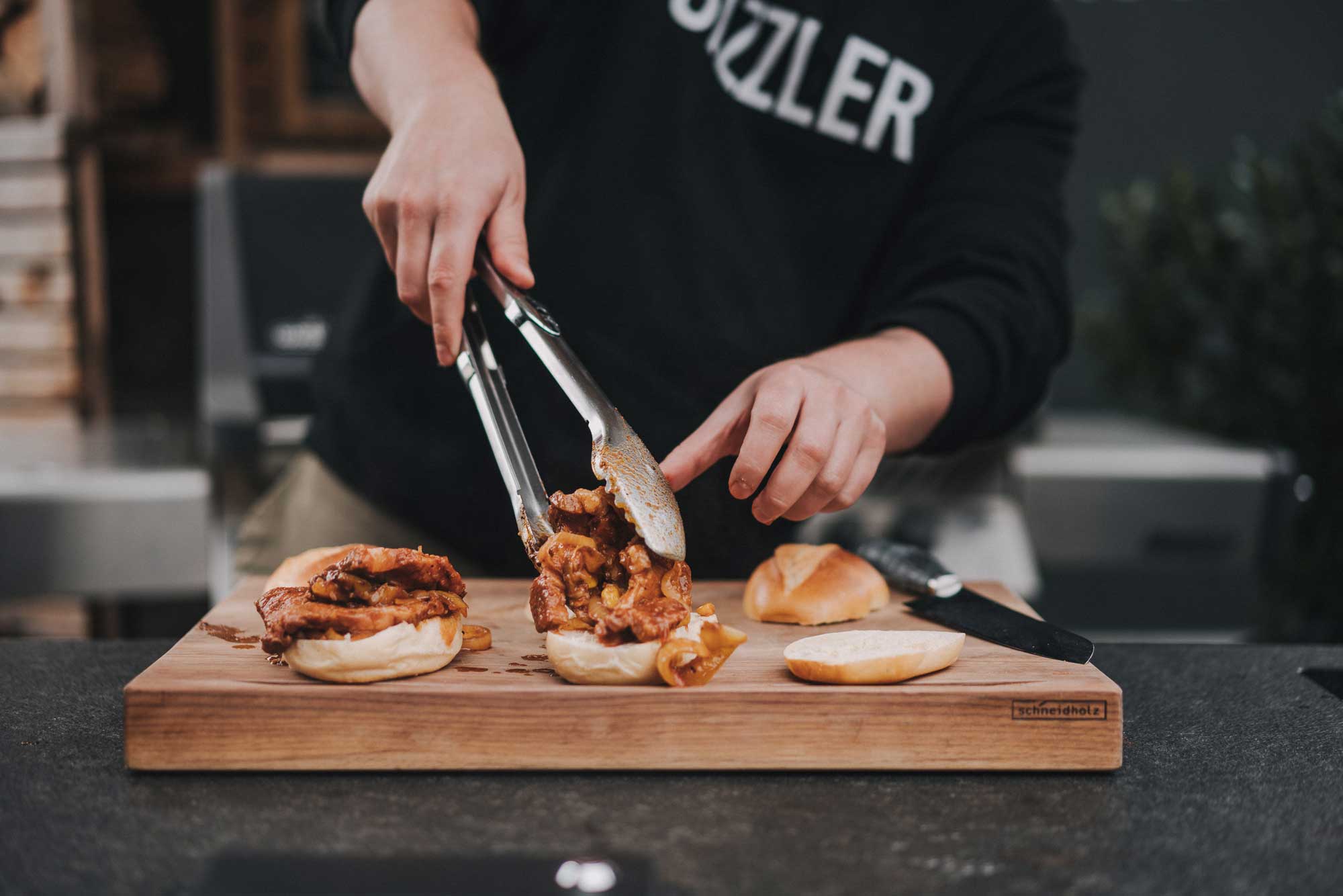 Schichtfleisch wird auf Brötchen angerichtet