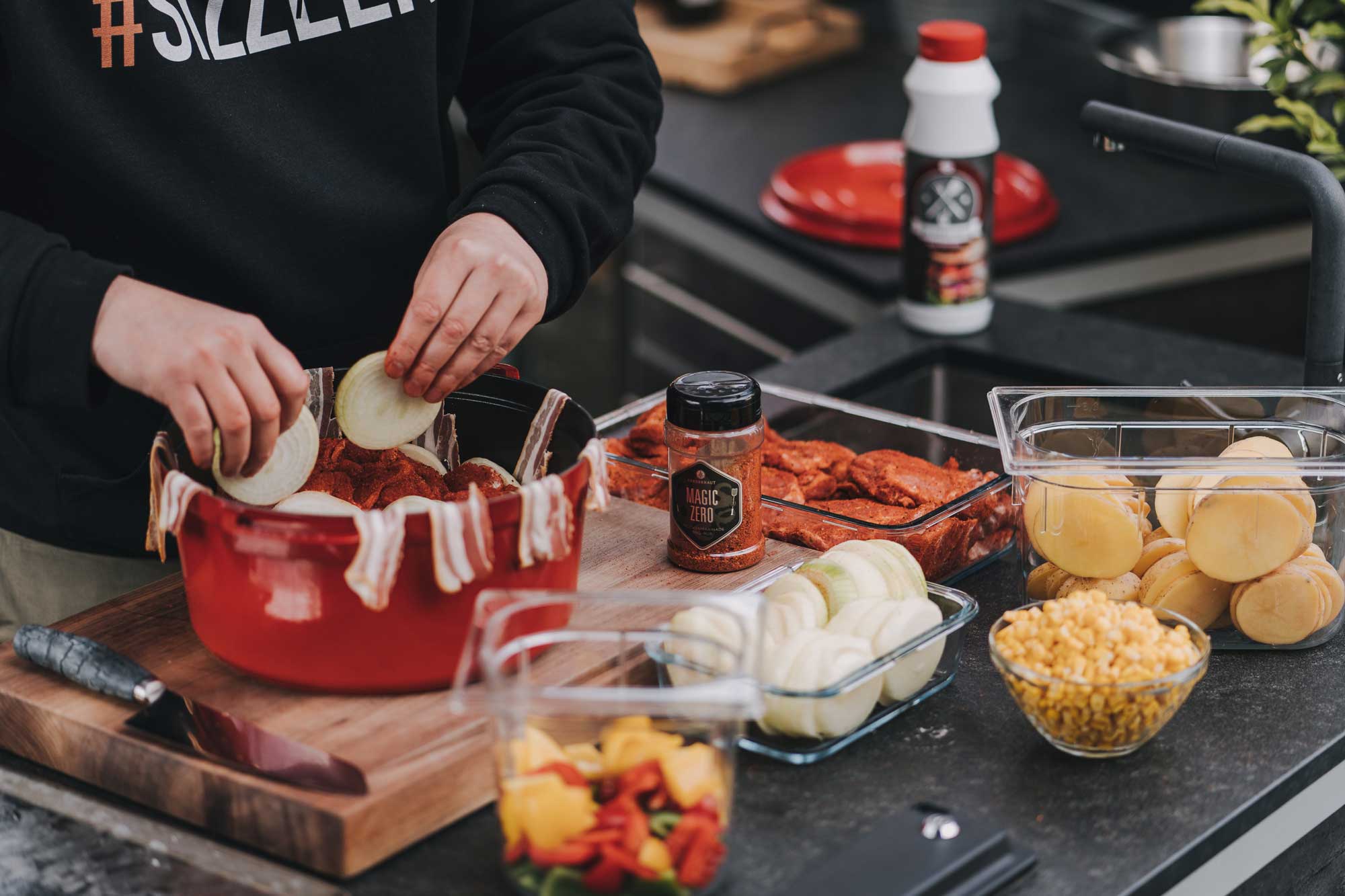 Dutch Oven wird mit Bacon und Zwiebel ausgelegt