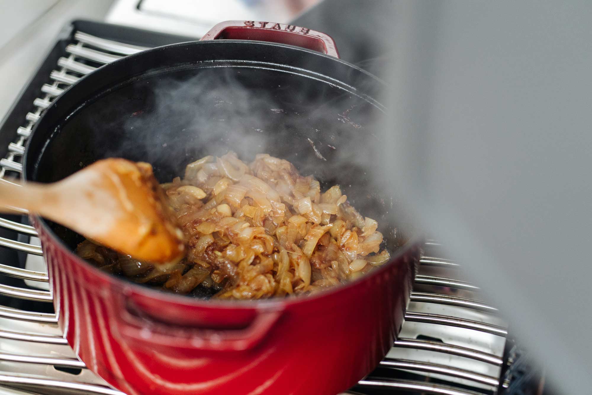 In einer Kokotte werden die gesamten Zwiebeln braun gebraten
