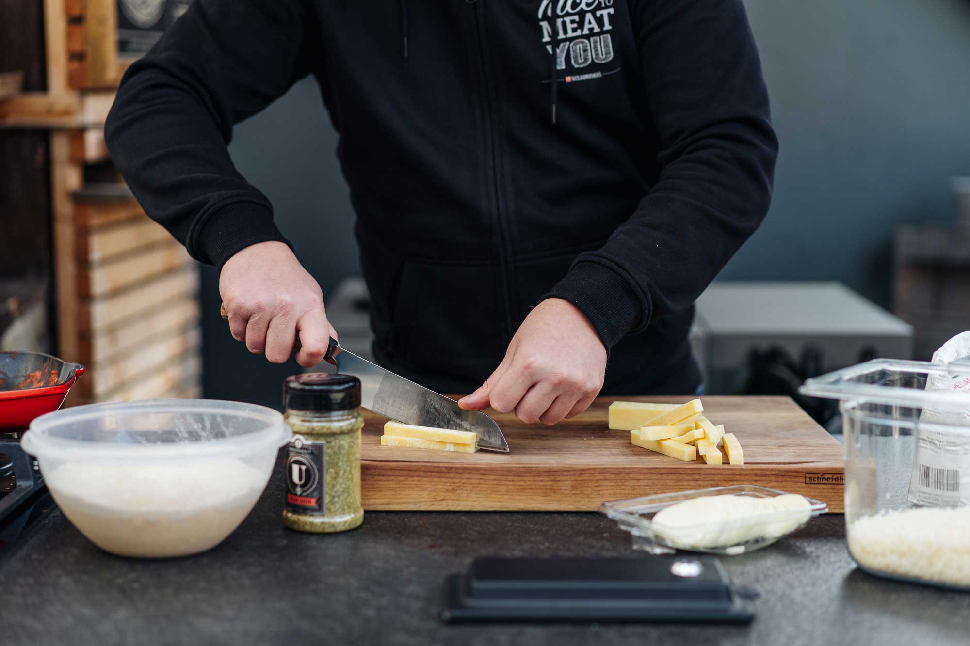 Für die New York Pizza wird Cheddarkäse in Scheiben geschnitten