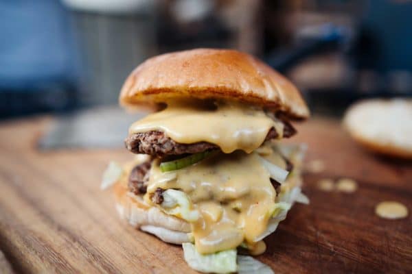 Die Chili Cheese Sauce läuft aus einem Burger heraus