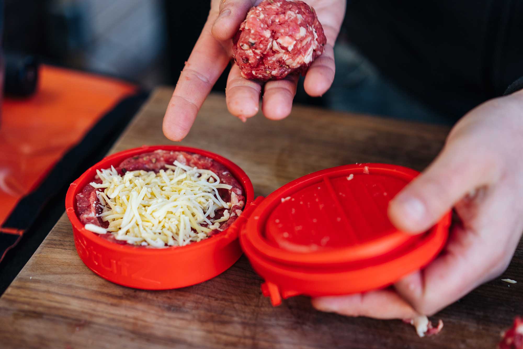 In einer speziellen Burgerpresse wird Hackfleisch mit Käse zu einem Patty gepresst