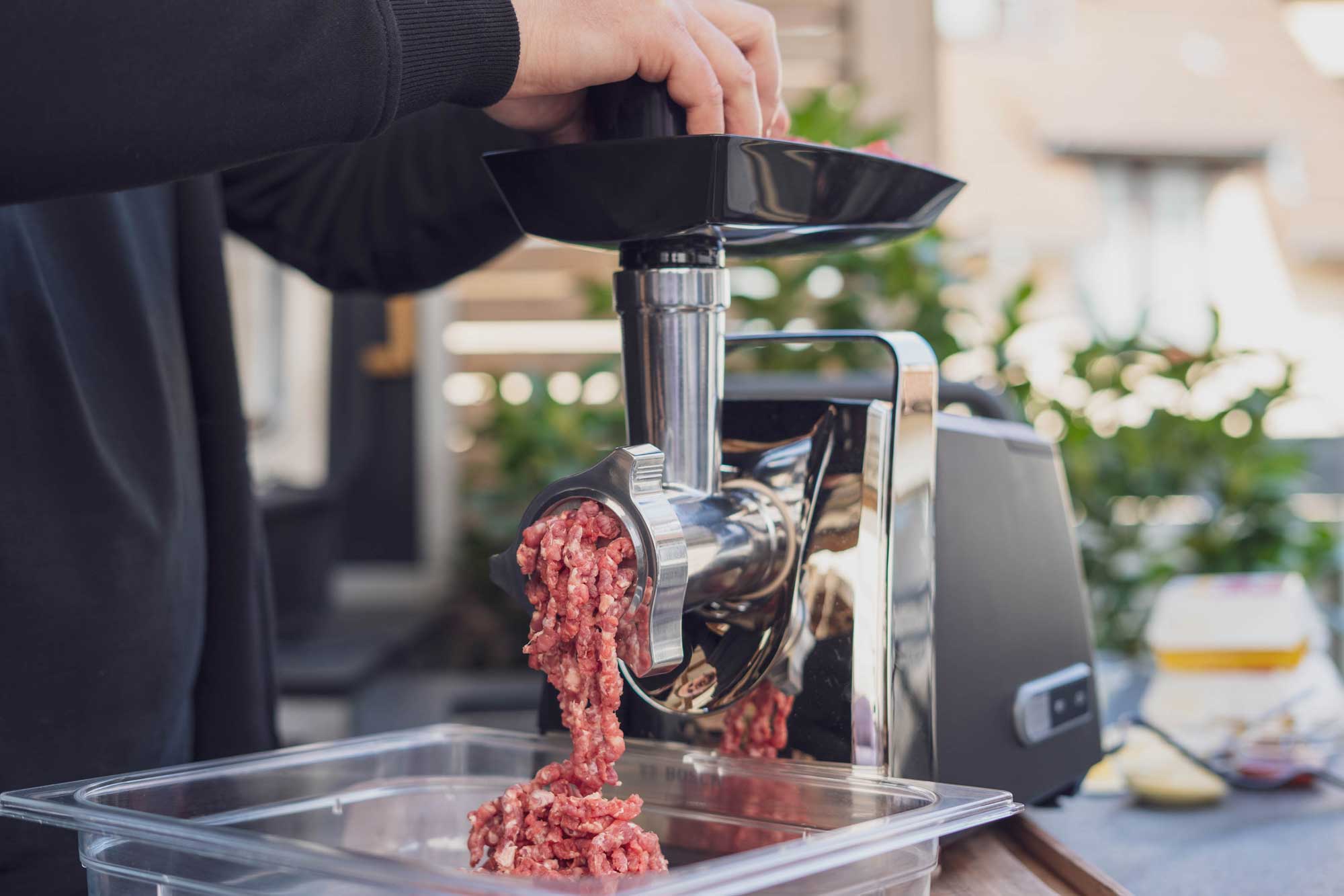 Das Rindernacken Fleisch für den Hamburger Royal Käse wird durch den Wolf gedreht