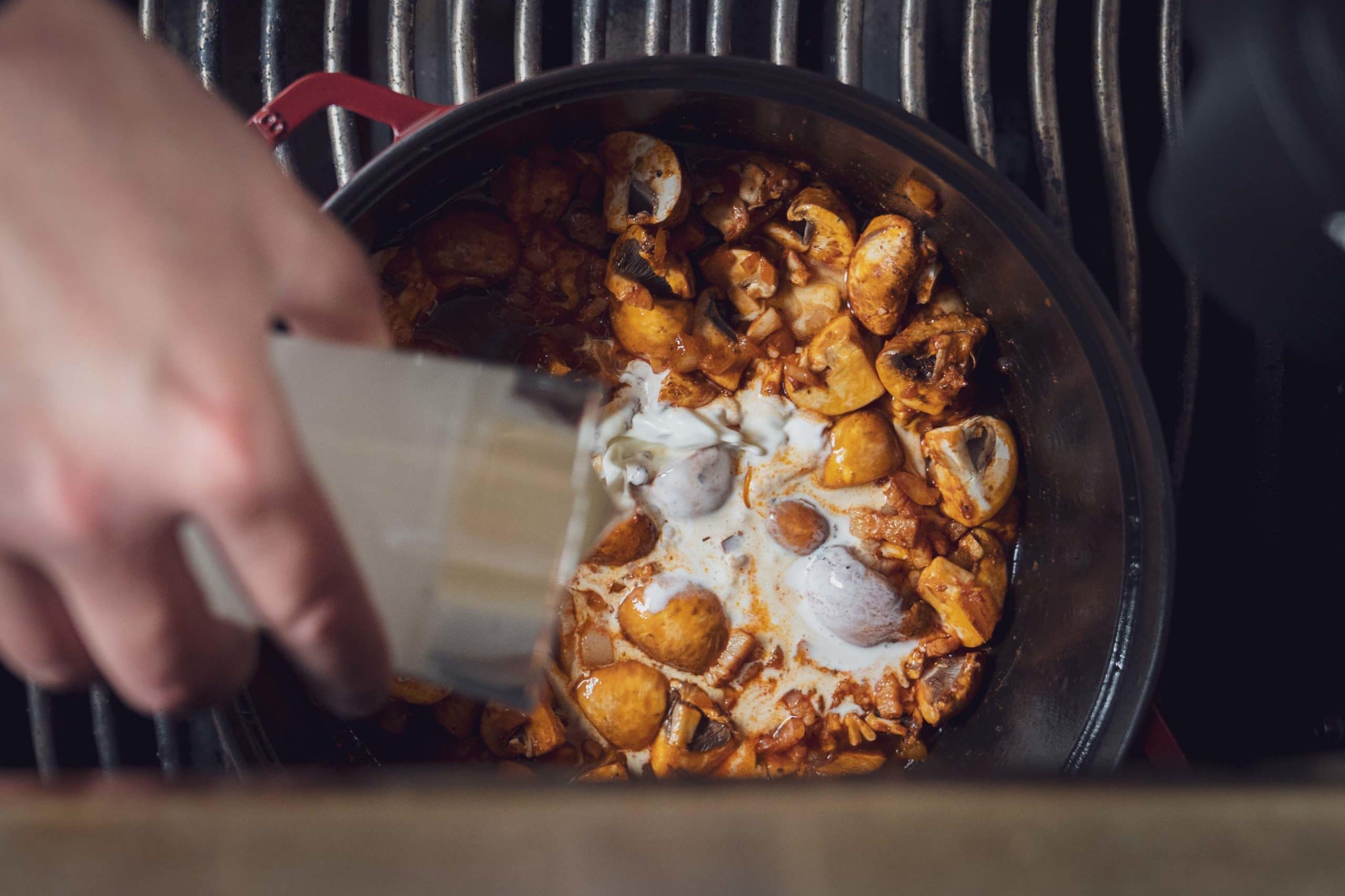 Abgelöscht werden die Zutaten des Filettopf im Dutch Oven mit Fond, Sahne und Schmand