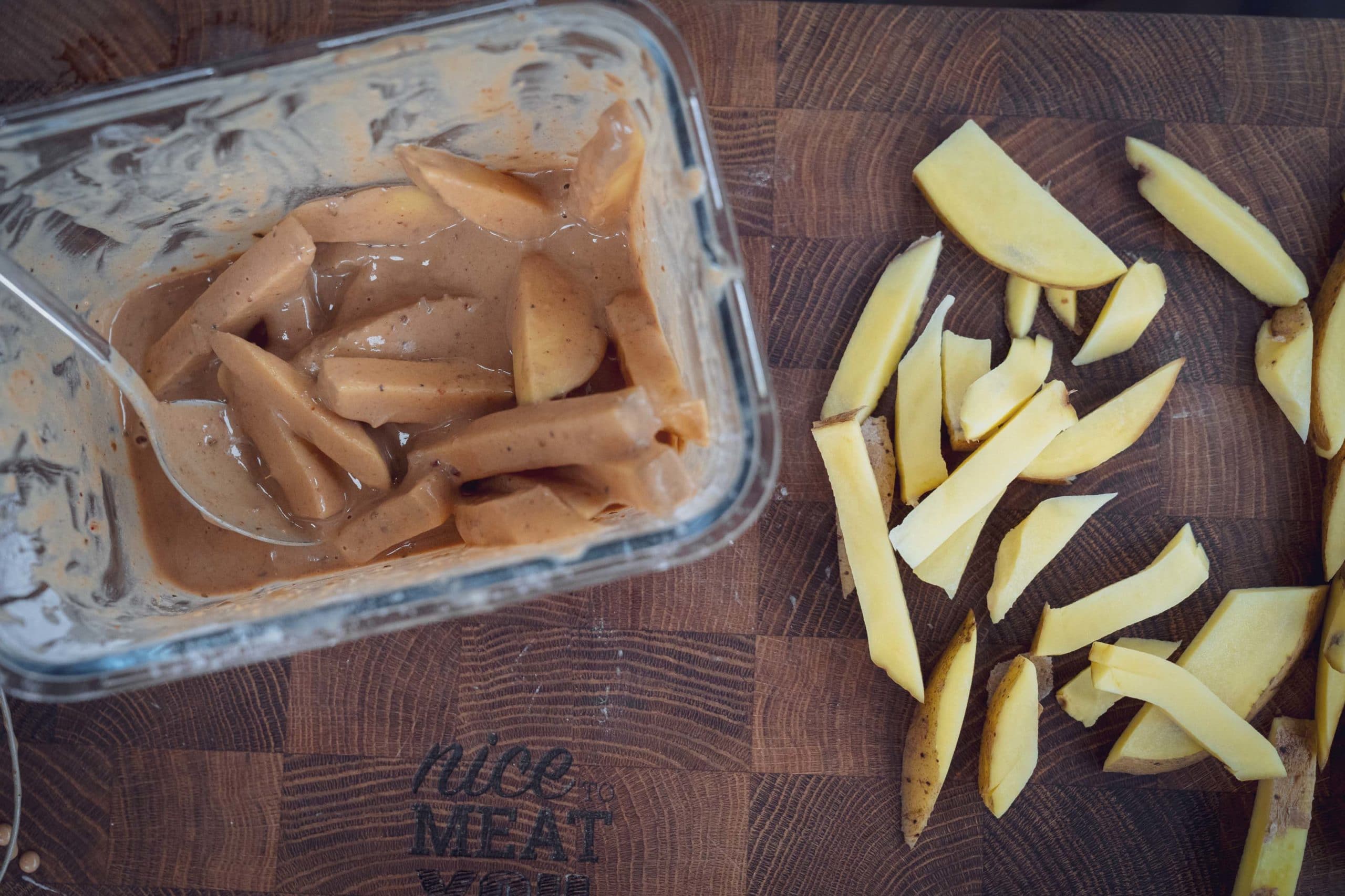 Die gewässerten Pommes in die Marinade geben