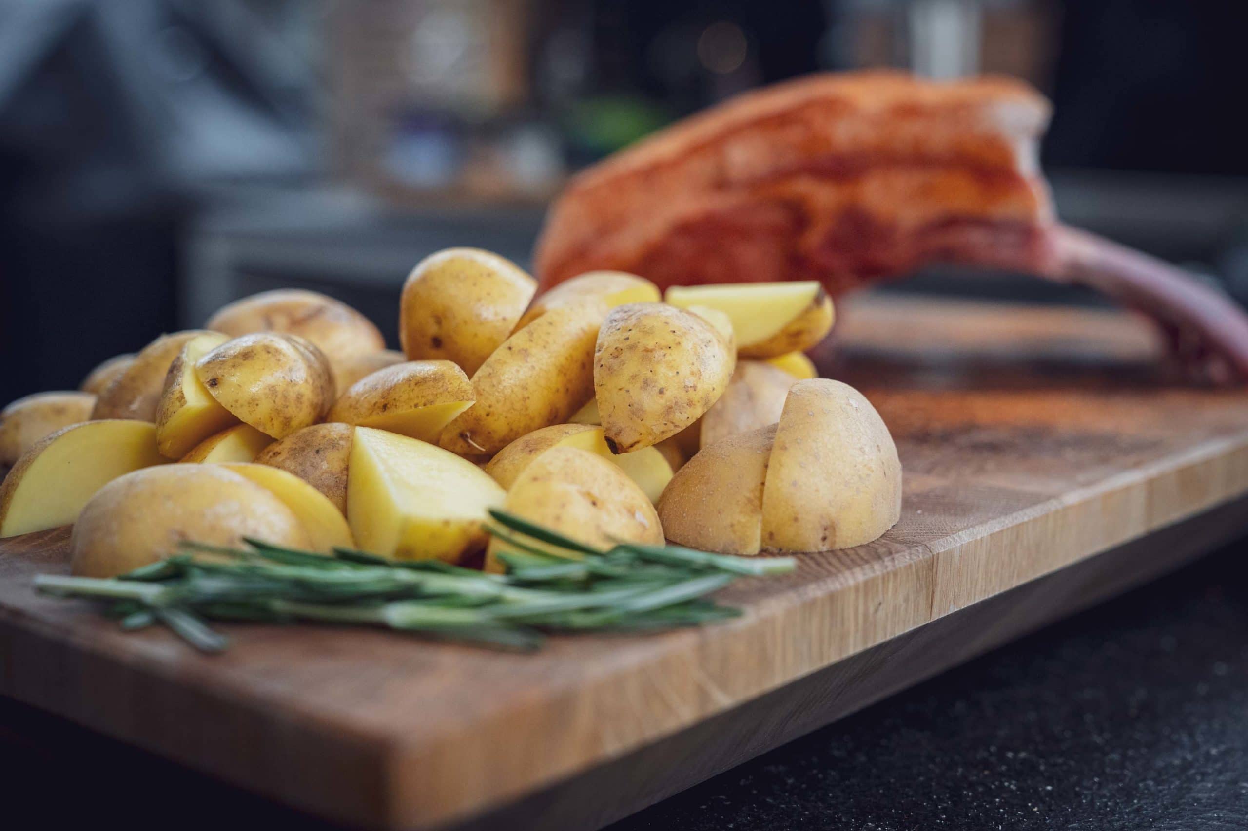 Frische Kräuter und Kartoffeln auf einem Brett