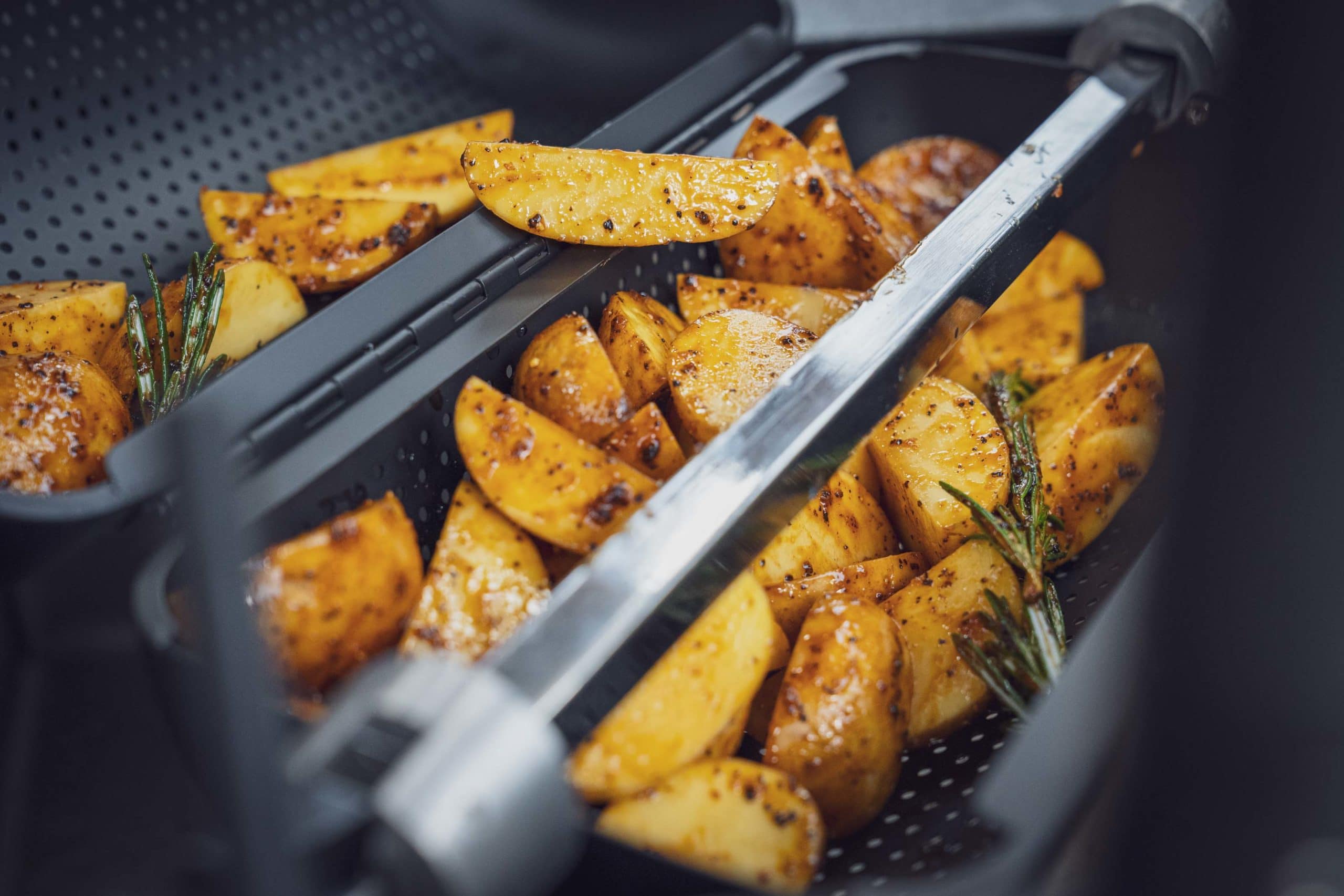 Kartoffeln mit Knoblauch liegen im Korb auf dem Drehspieß