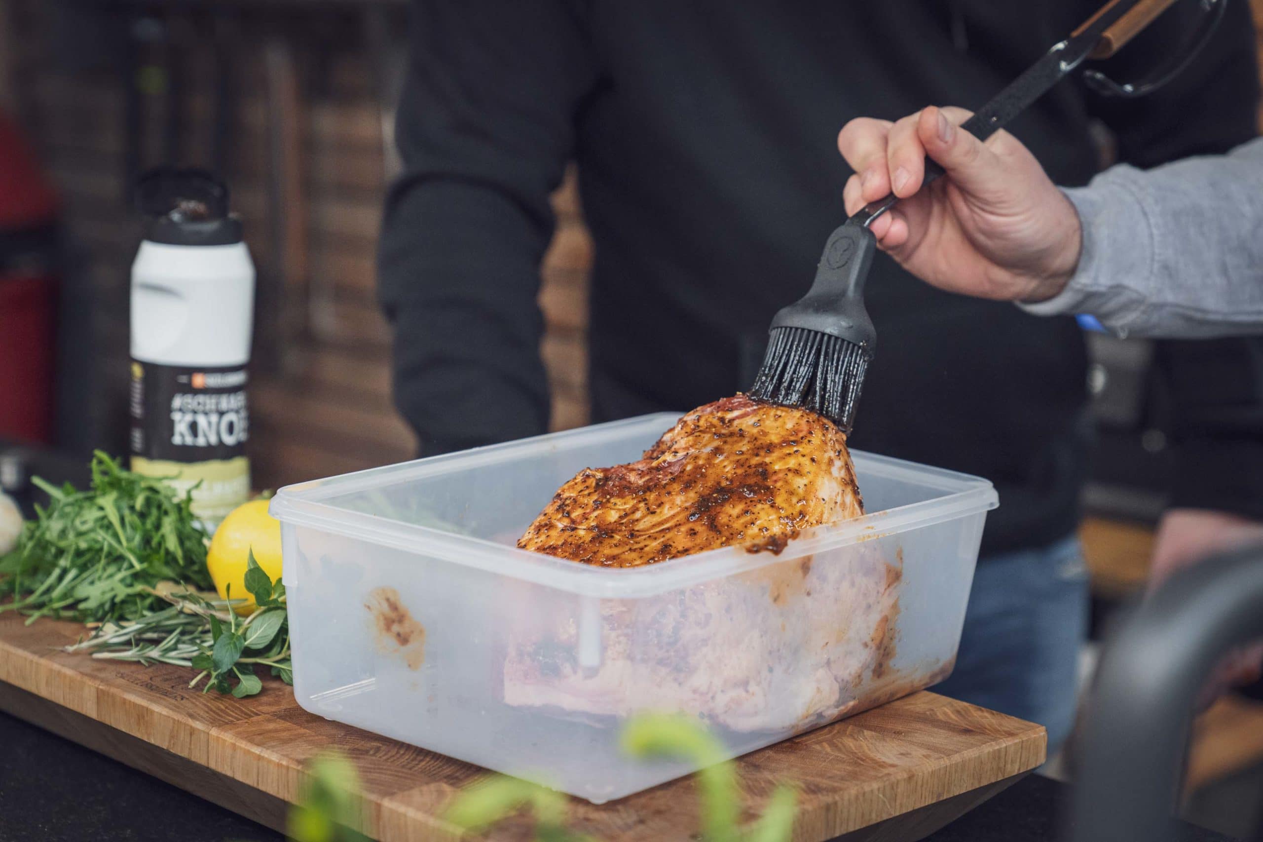 Die Lammkeule wird mit einem Silikonpinsel und der Knoblauchmarinade eingerieben