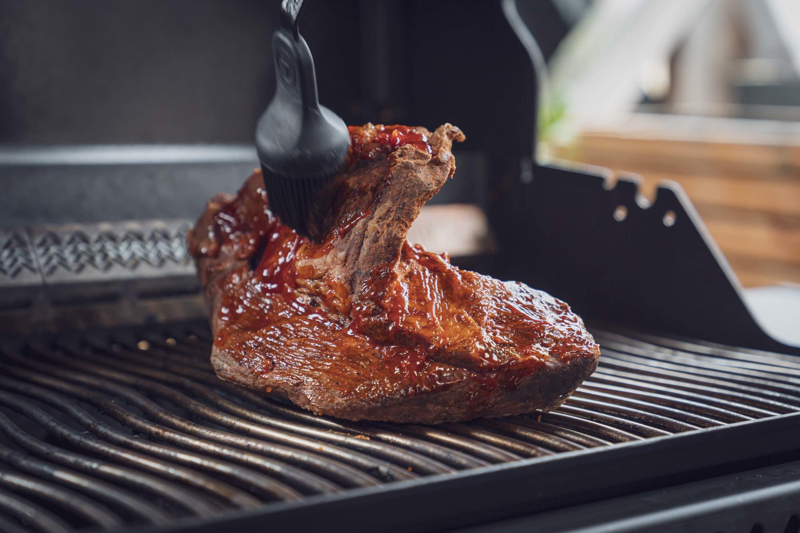 Das Beef Brisket wird mit der Umami Sauce auf dem Grill glasiert