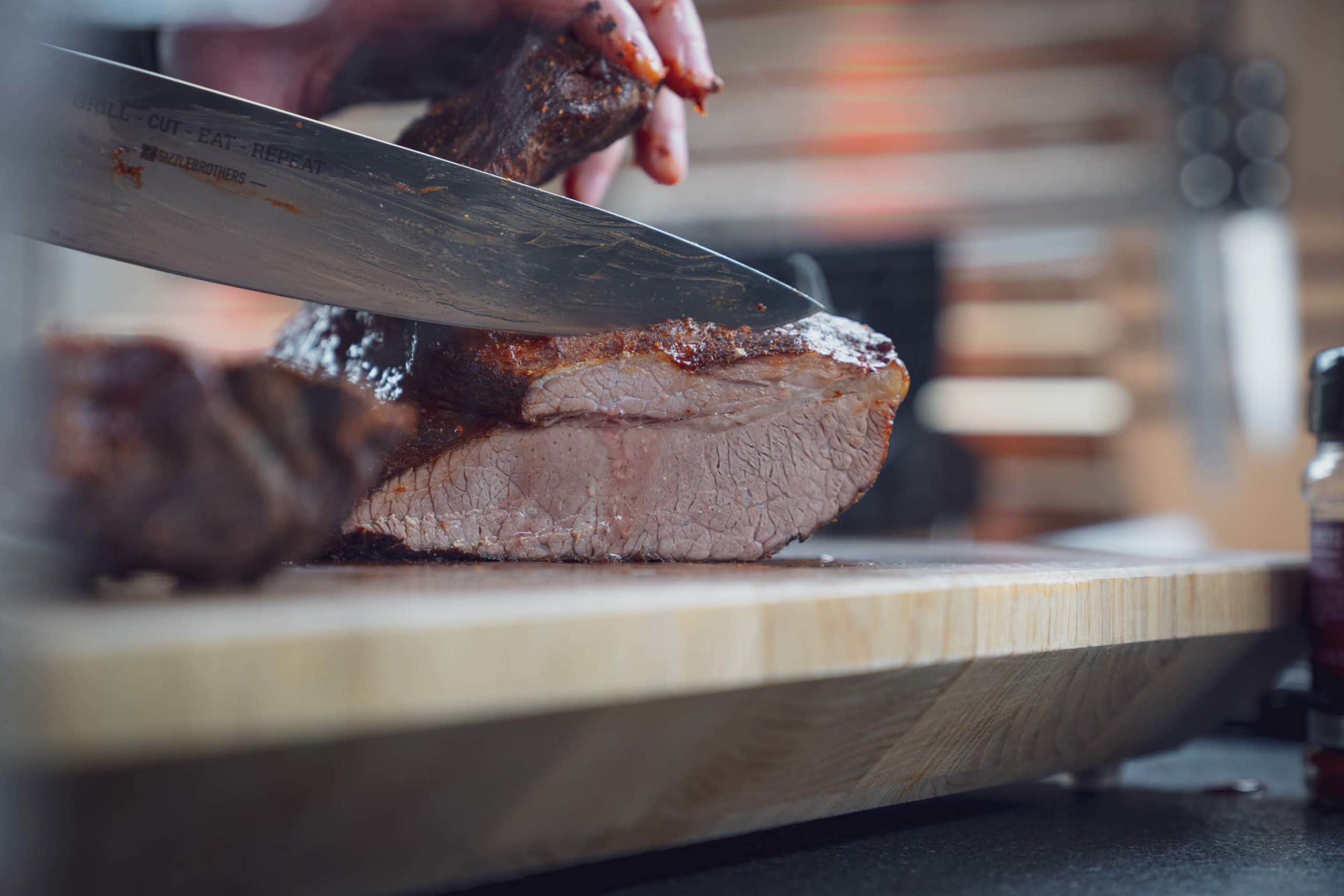 Das Beef Brisket wird mit einem Kochmesser angeschnitten