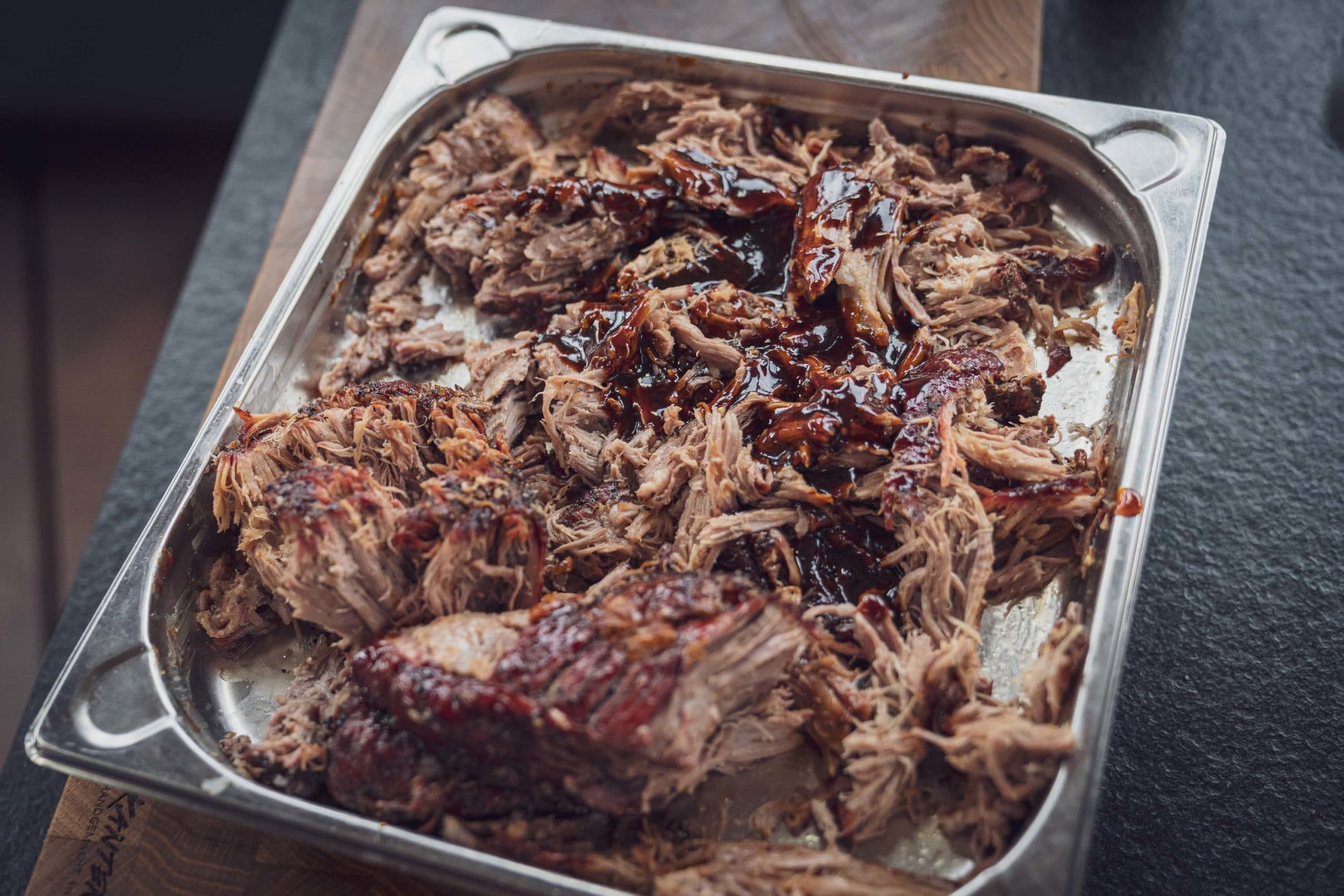 Fertig gegartes Pulled Pork in einer Schale vom Gasgrill