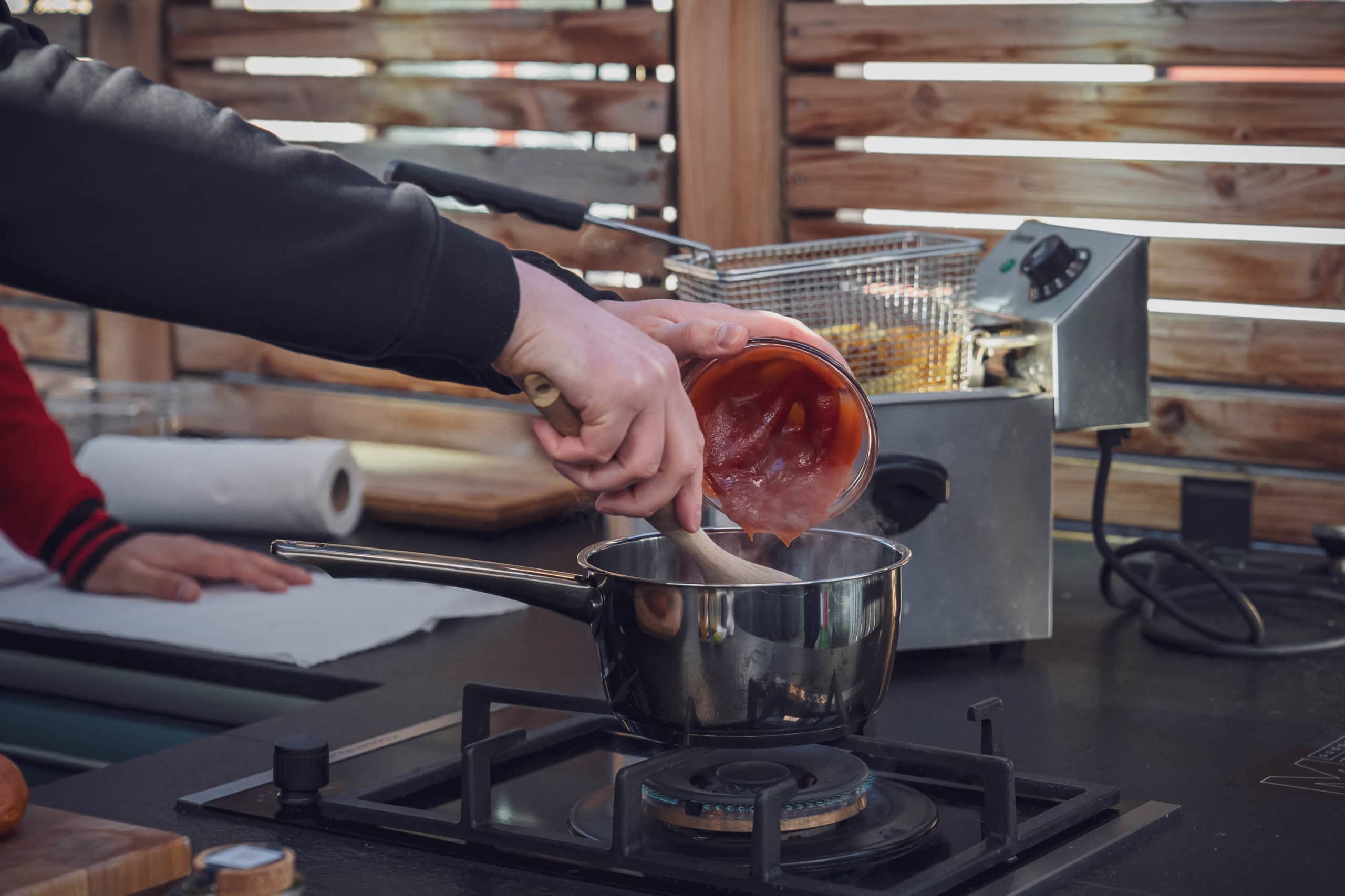 Tomatenketchup für die Currysauce wird in den Topf gegeben