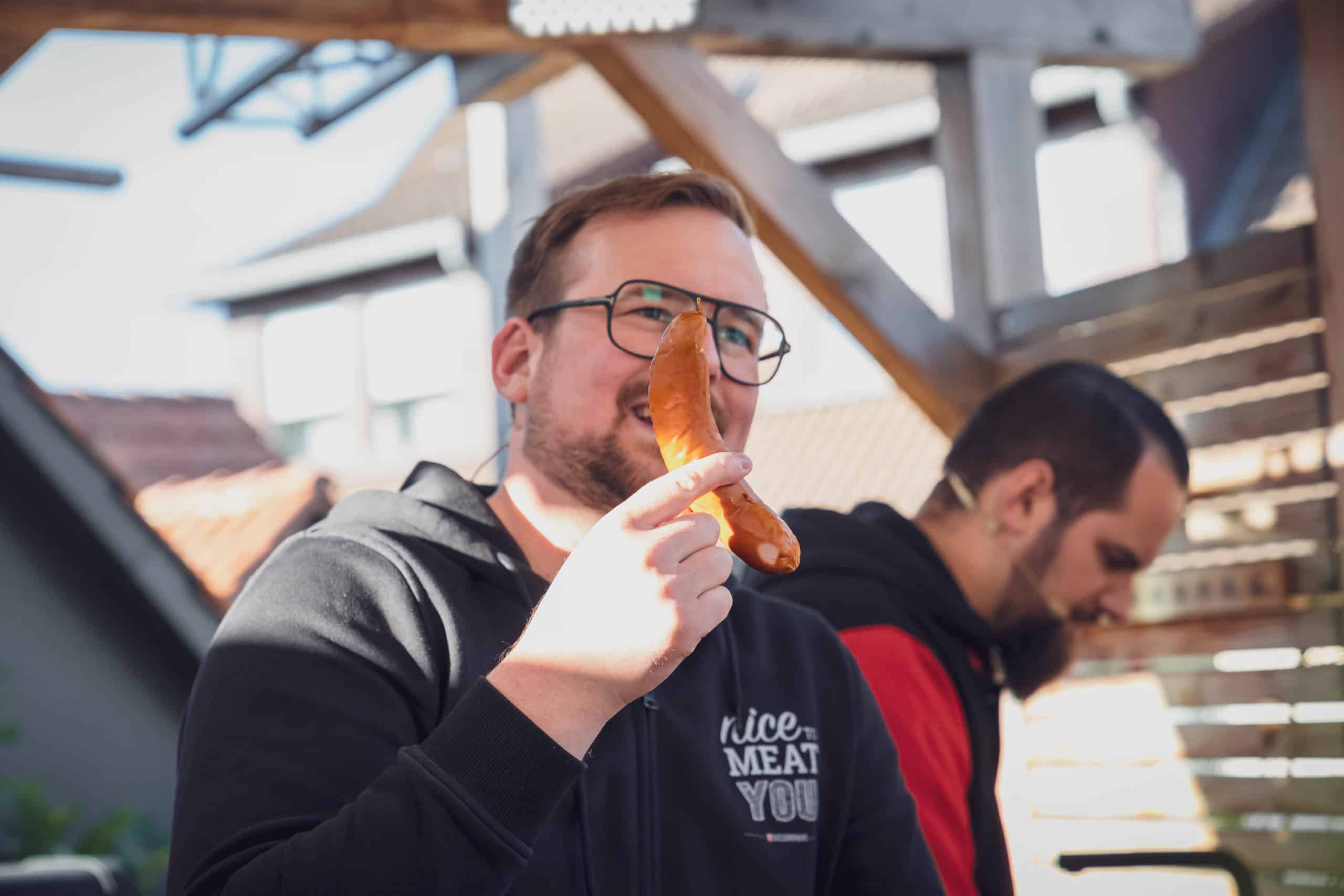 Julian hält die Currywurst in der Hand