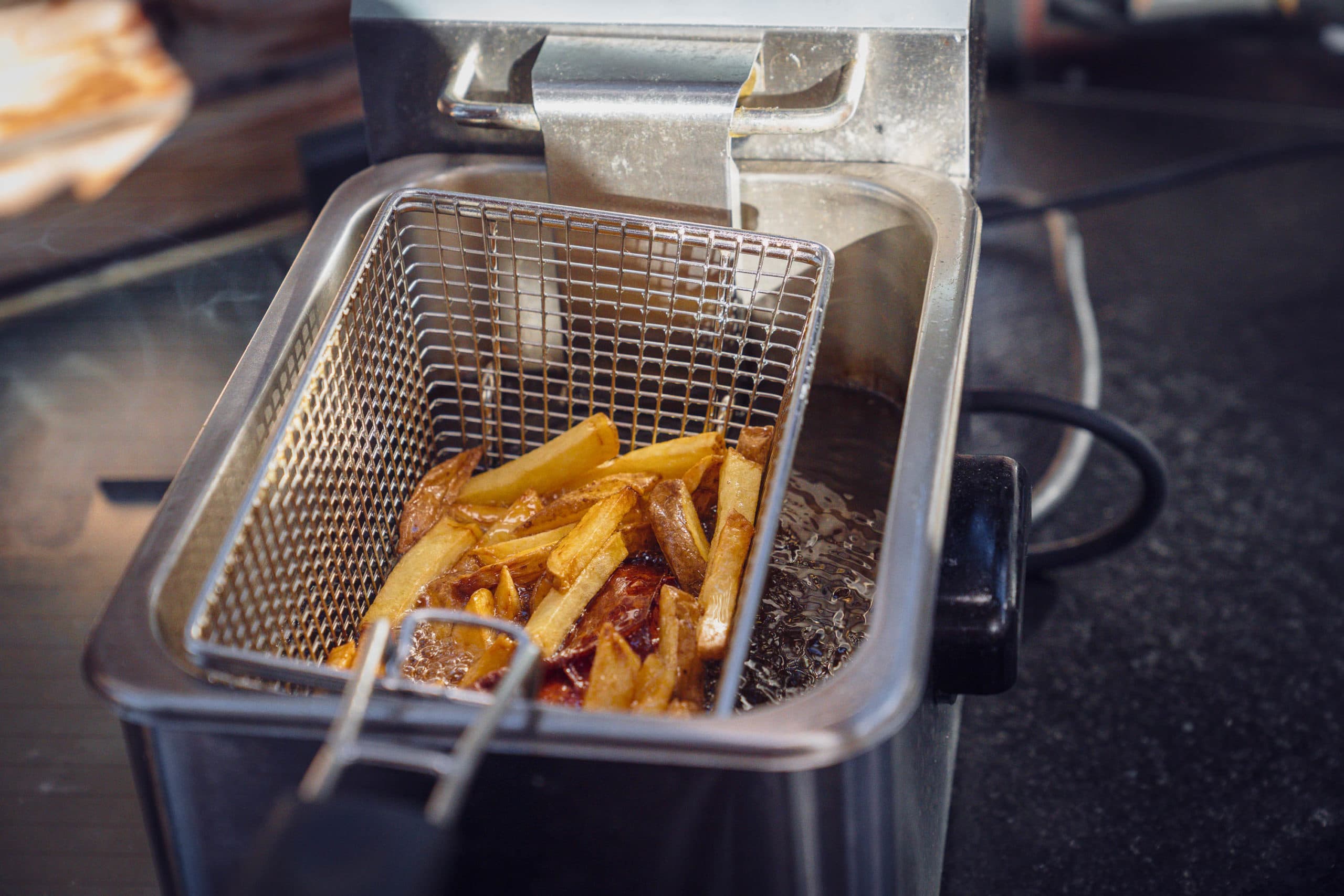 Pommes werden goldbraun frittiert