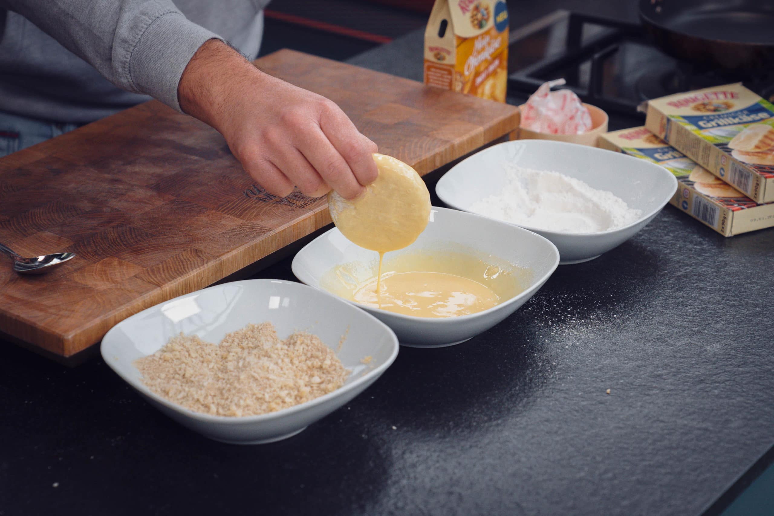 Der Käse wird in Mehl, Ei und Paniermehl paniert