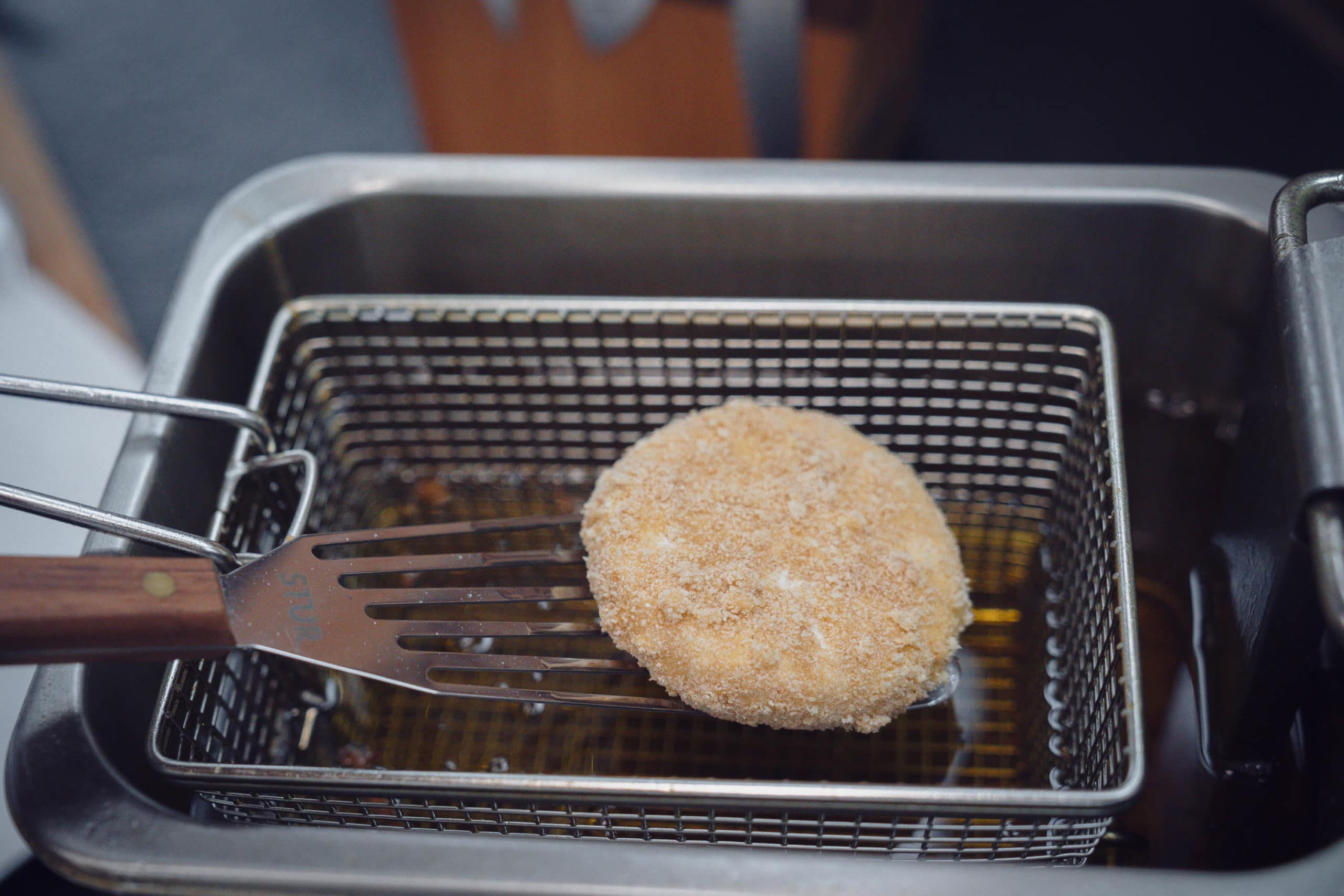 Der Grillkäse wird vorsichtig in das siedende Fett gegeben