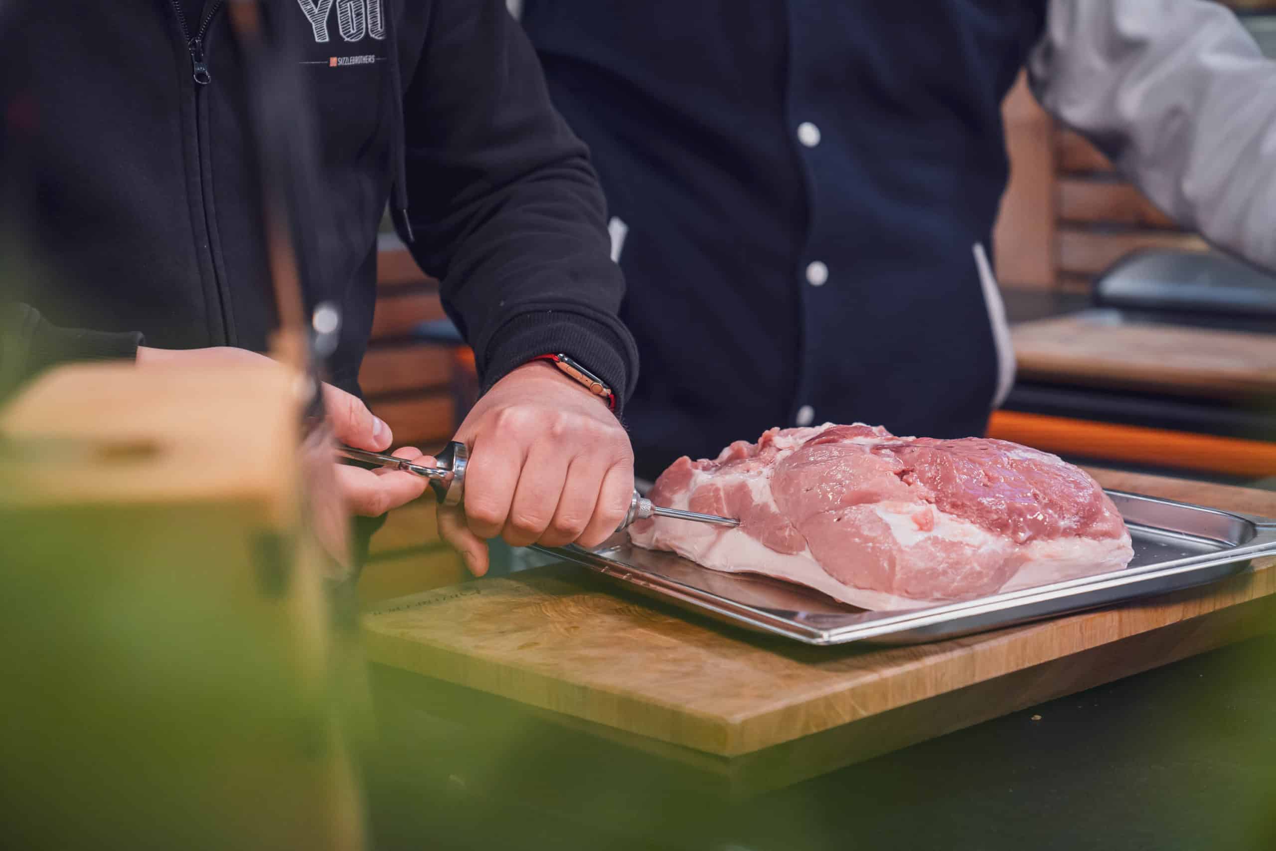 Der Krustenbraten wird mit Weißwein gespritzt