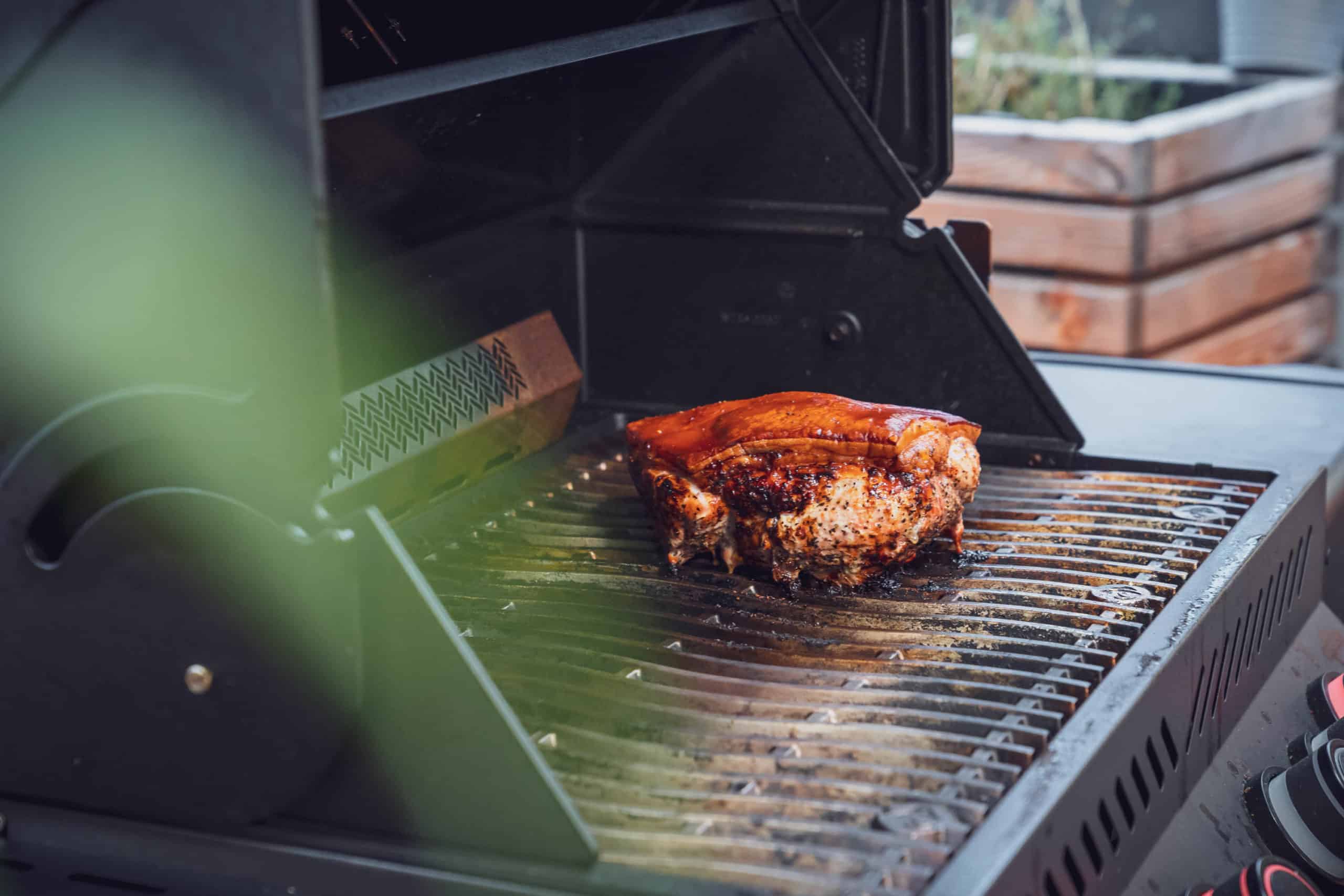Der Krustenbraten liegt auf den Gasgrill