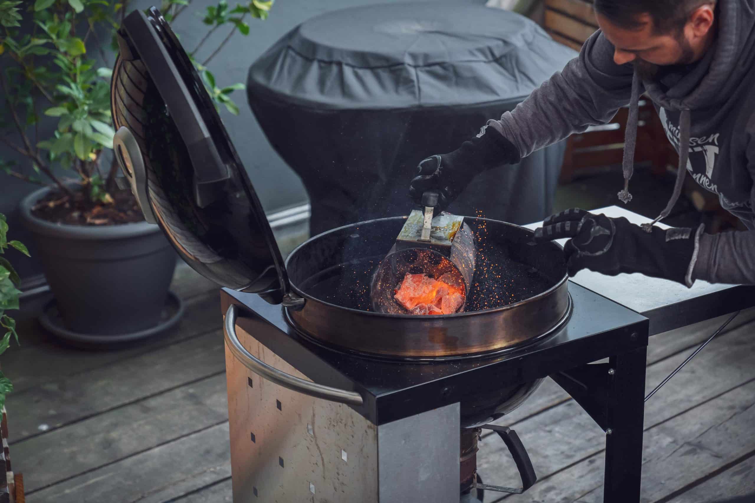 Die Kohlen werden in den Grill gekippt