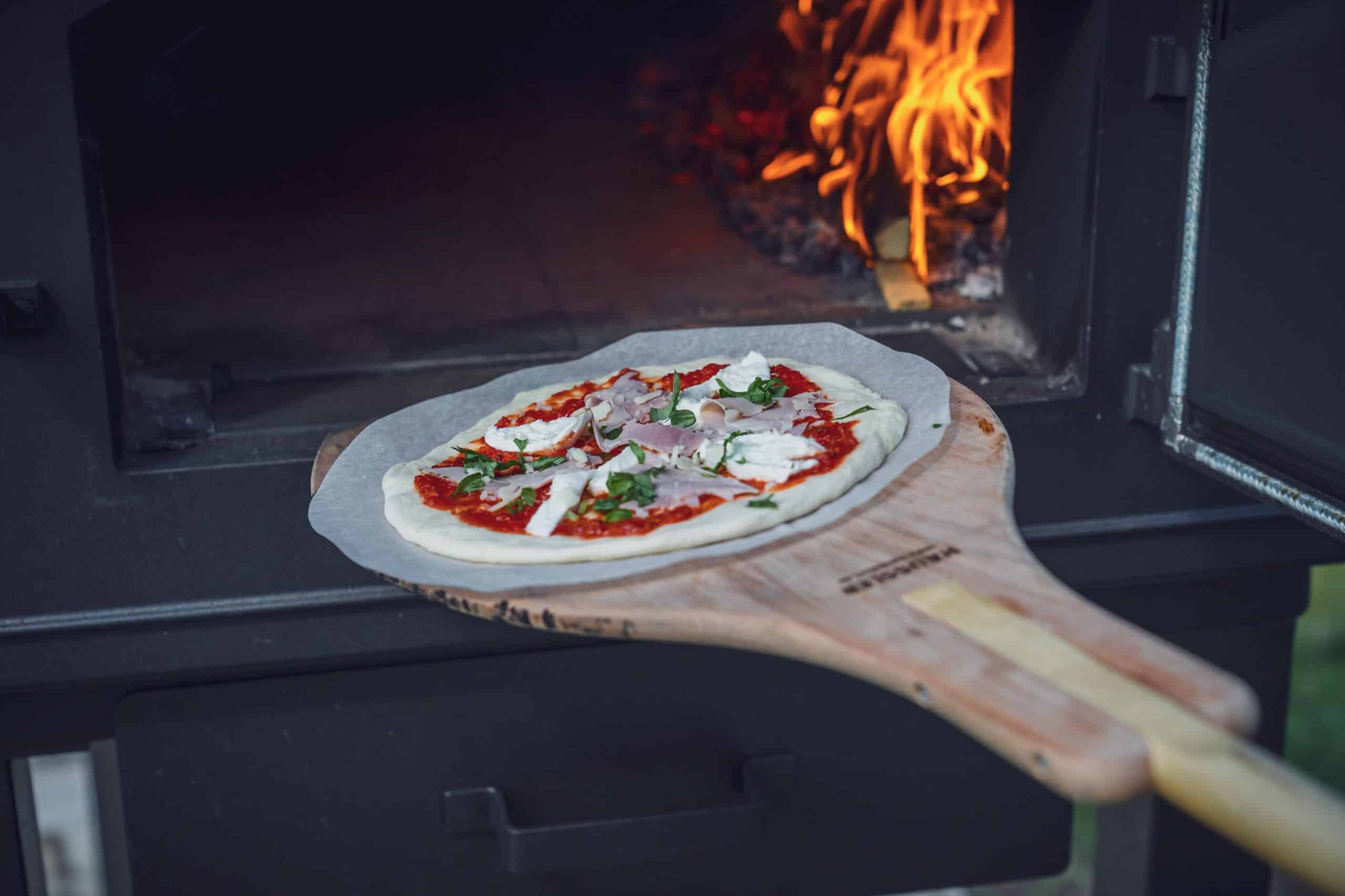 Pizza wird in den Backofen gegeben