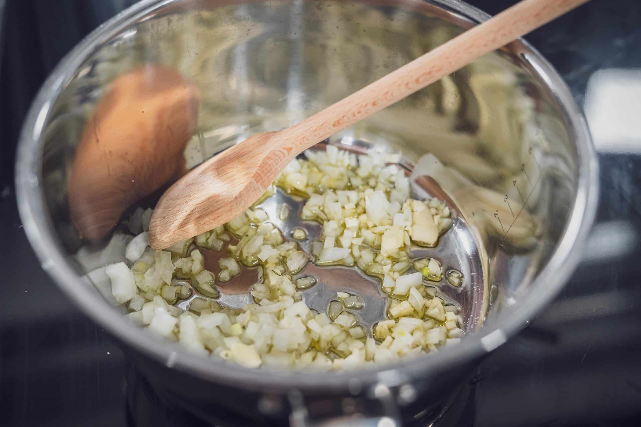 Zwiebeln und Knoblauch werden im Topf erhitzt