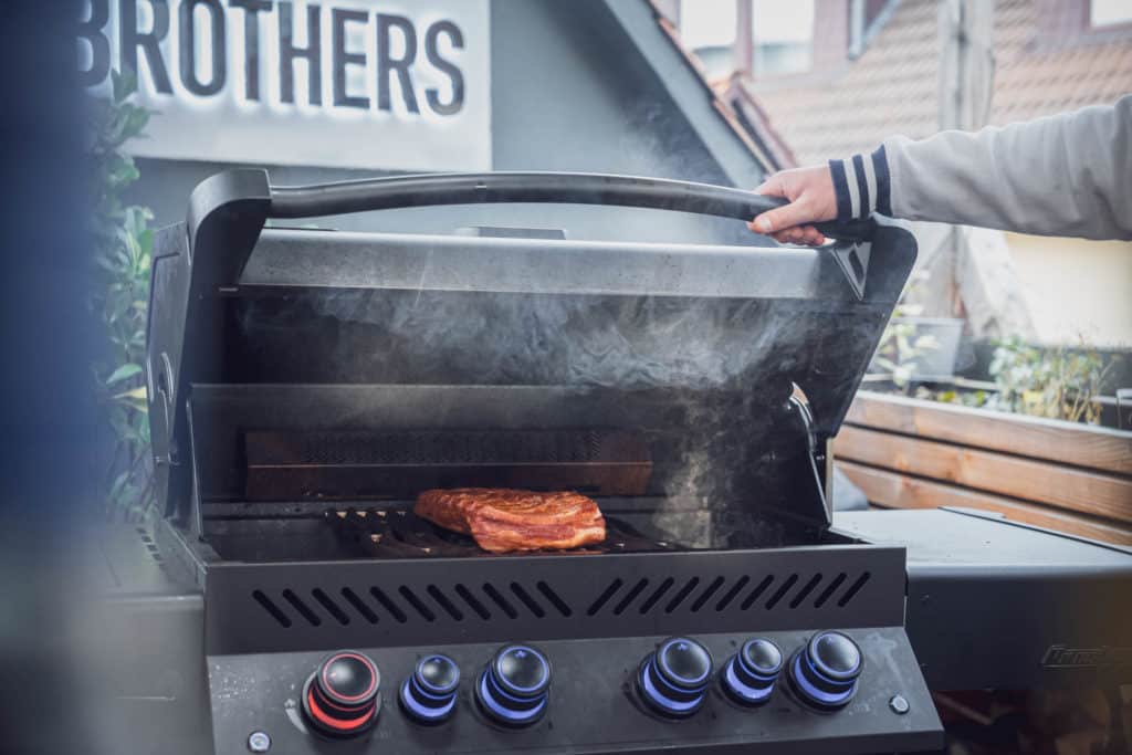Der Gasgrill räuchert/smoket